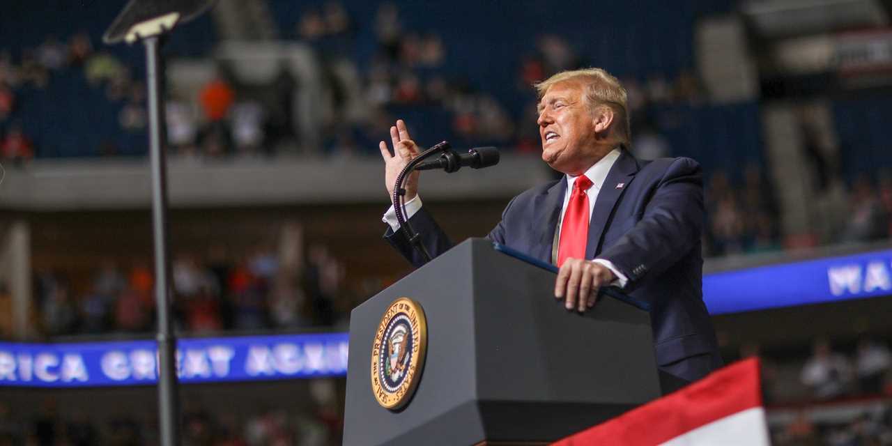 Donald Trump speaking at a lectern with the presidential seal in an arena in Tulsa, Oklahoma.