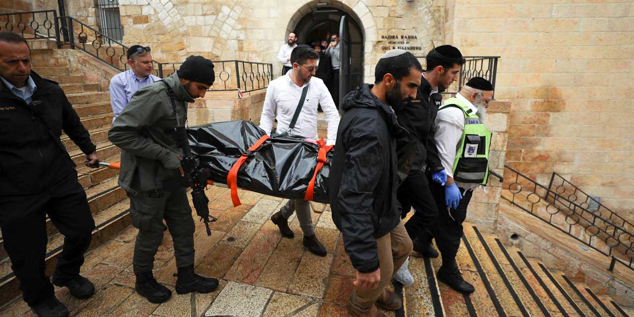 Israeli security personnel carry a dead body down the steps following an incident in Jerusalem's Old City November 21, 2021.