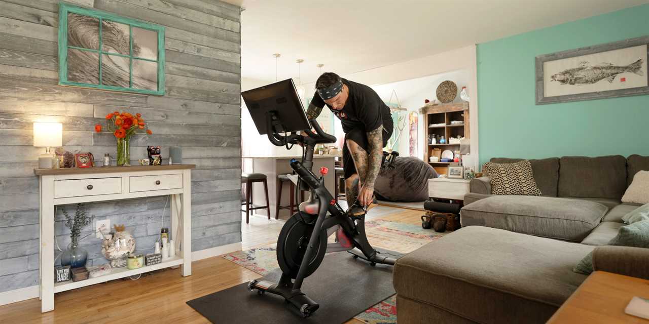 A man riding a Peloton bike in his living room.